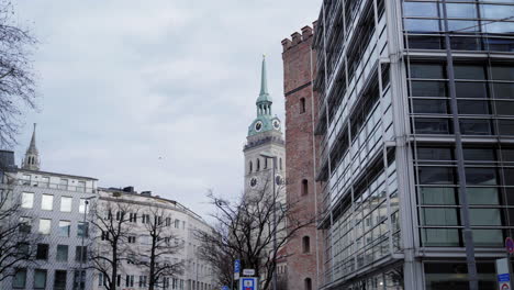 urban landscapes combining modern and historic architecture: glass, stone, brick. a winter daytime atmosphere, passersby, bare trees, streetlights, and the st.-jakobs-platz bus stop.