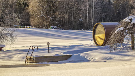 Schöne-Zeitrafferaufnahme-Einer-Holzfasssauna-Neben-Einem-Zugefrorenen-Weißen-See-Im-Winter