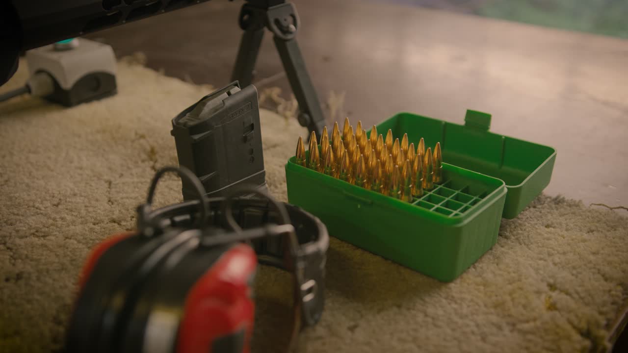 caja de munición con proyectiles, cargador y orejeras acústicas en el campo de tiro