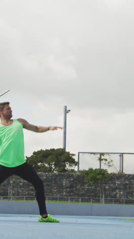 side view of caucasian athlete throwing javelin