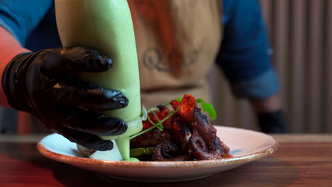 aderezo del chef con mousse de aguacate al plato de tentáculos de pulpo