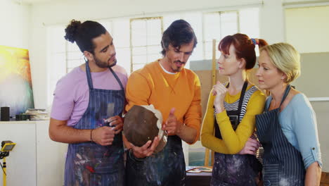 profesor de dibujo ayudando a los artistas en la escultura de cerámica 4k