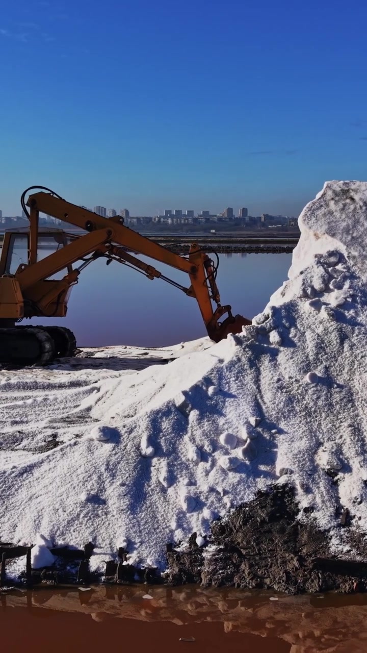 Salt pile near a water body in a salt production area on a sunny day