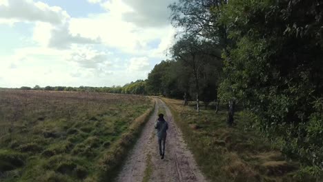 shot following guy running through nature