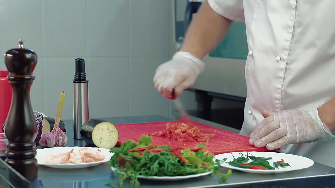 el cocinero corta un tomate para una ensalada