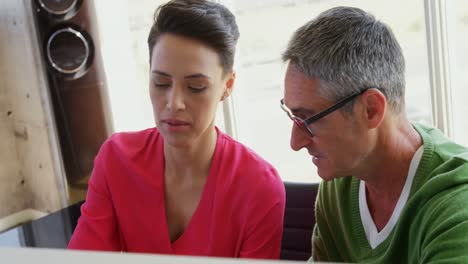 Front-view-of-Caucasian-Business-people-discussing-over-computer-at-desk-in-office-4k