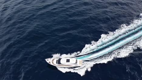 aerial video capturing a luxury yacht cutting through deep blue ocean waters, leaving a dynamic