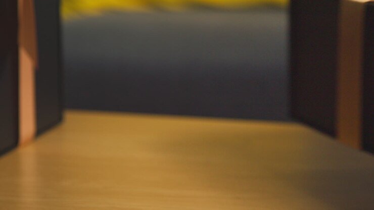 Close Up Of Man Picking Up Gift Wrapped Present From Table In Lounge At Home
