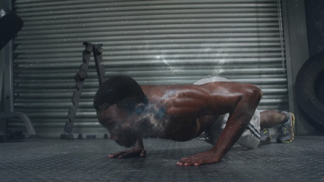 Male trainee starting top, performing push-ups in gym for fitness, smoke particles accenting chest