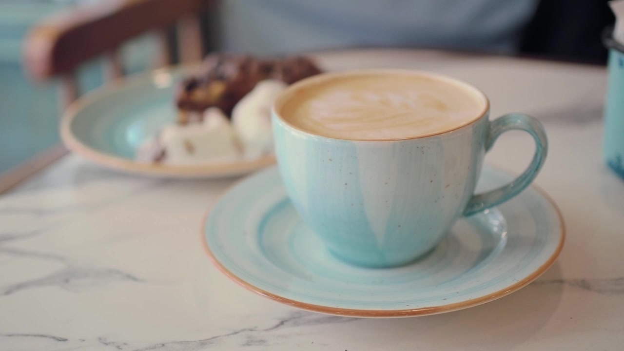 Una tazza di latte macchiato su un tavolo di marmo in un caffè