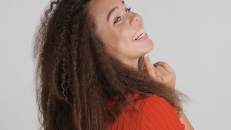 Caucasian-curly-haired-woman-smiling-to-camara.