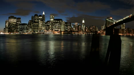 Wolken-Werden-Rosa-Und-Lila-Und-Lichter-Erleuchten-Die-Skyline-Von-New-York-City,-Während-Die-Goldene-Stunde-Zur-Nacht-Wechselt-To