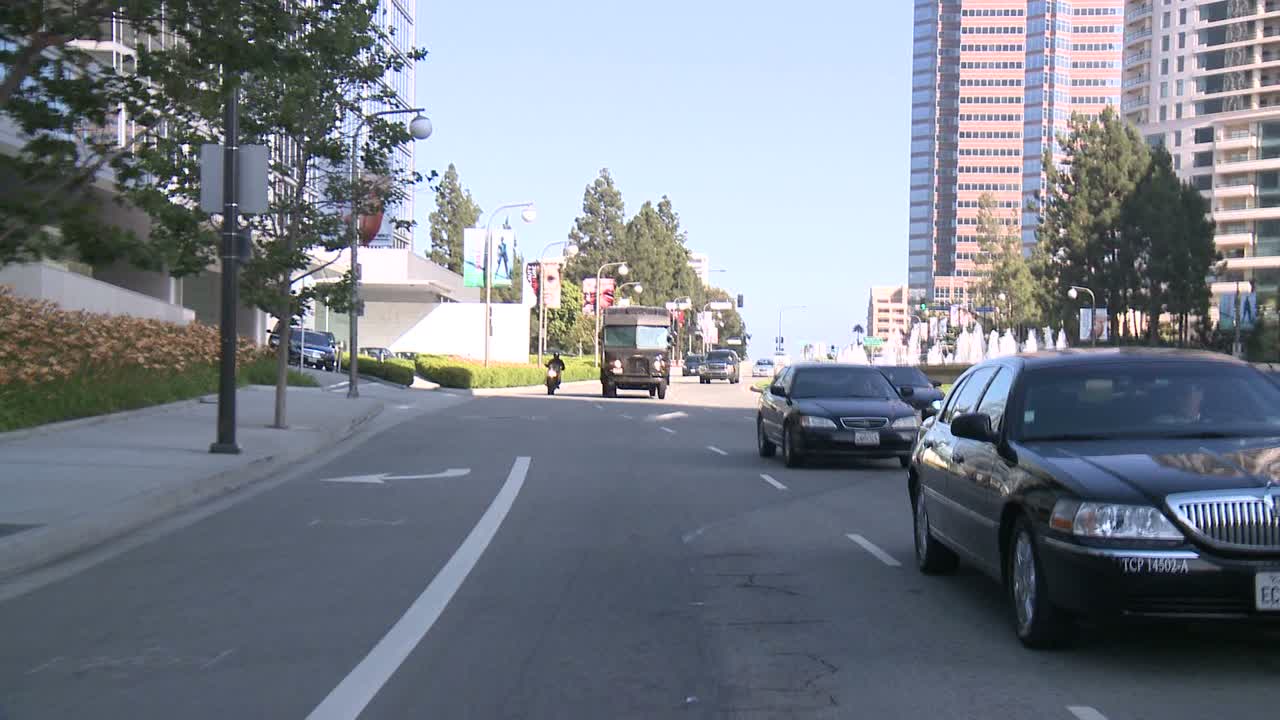 뒷창 2를 통해 보이는 센추리 시티 로스앤젤레스의 거리를 따라 자동차가 이동합니다.