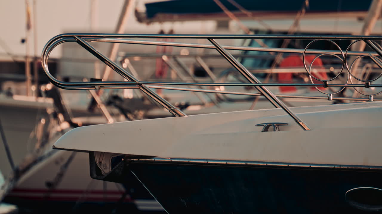 Close up of the yacht bow with chrome railing docking in a marina