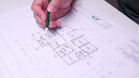 An individual checking the draft of an architectural flor plan of a proposed building