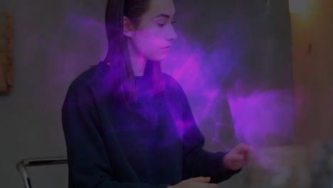 female designer interacting with purple holographic mist in studio, showcasing tech visual concept