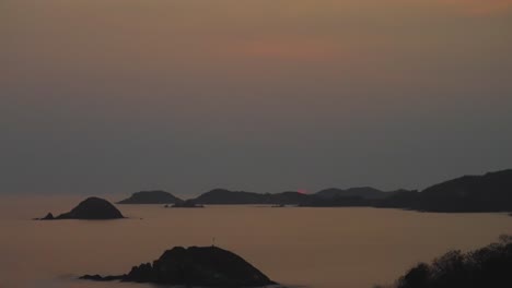 sunset over the ocean with islands