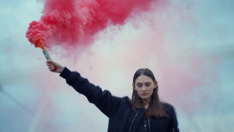 Woman-standing-on-street-with-smoke-bomb-in-hand.-Girl-holding-smoke-grenade