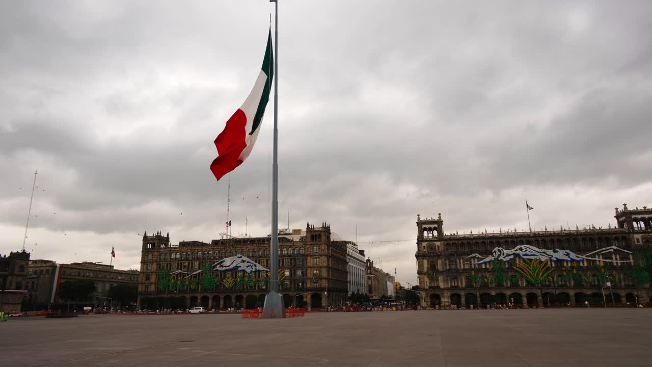 Bandiera messicana che sventola, edifici storici e auto sullo sfondo, centro metropolitano di Città del Messico alla luce del giorno