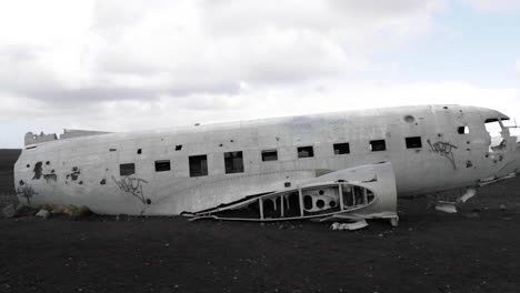 Tiro-Inclinado-Hacia-Arriba-De-Un-Viejo-Avión-Estrellado-En-Una-Playa-Volcánica-De-Islandia-En-Cámara-Lenta