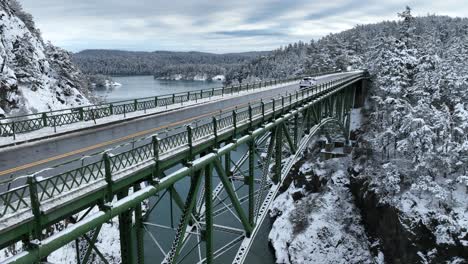 rising shot of a lone truck driving across deception pass bridge in the winter