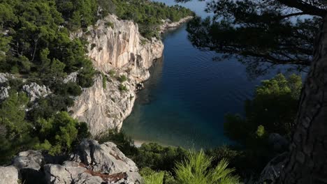 breathtaking hidden paradise beach cove, blue sea and dramatic mountain cliffs