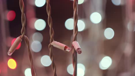 LED Christmas garlands blinking on the background of bokeh blurred lights. Concept. Close up of flashing lights of light pink color, New Year and Christmas time.