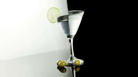 green olives falling in the cocktail glass