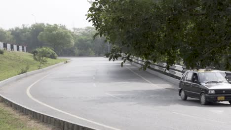 car driving on a curved road surrounded by trees