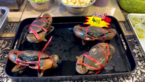 tied crabs displayed with price at market