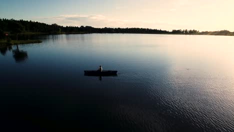 beautiful colorado sunrise on a lake with a silhouette of a canoe against the rising sun