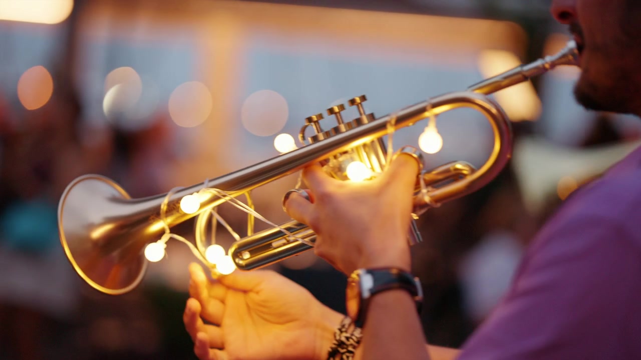 Musicista che esegue musica jazz su una tromba di ottone decorata con lucine, creando un'atmosfera festosa durante un evento serale.