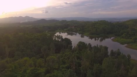 drone revealing a lake with sunset at background in venezuela with dramatic orange sky