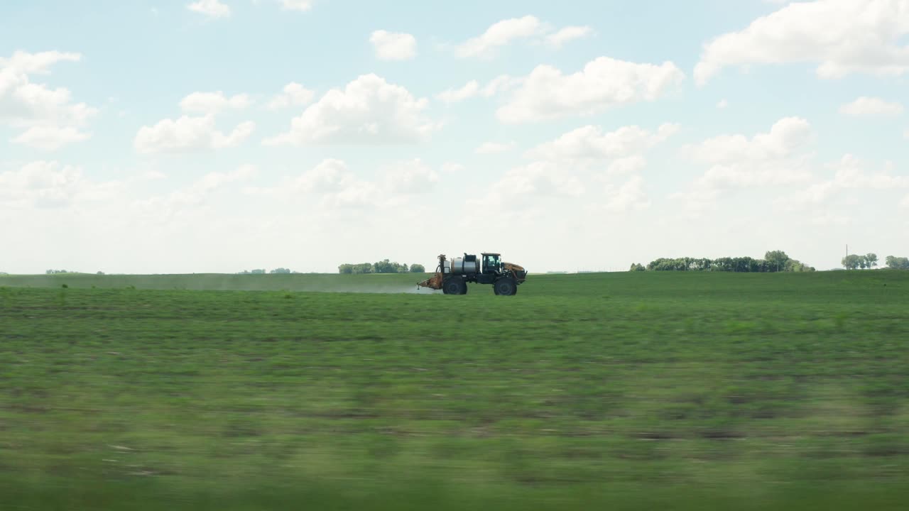 vista lateral aérea, tractor conduciendo pesticidas de fumigación rápida en cultivos agrícolas