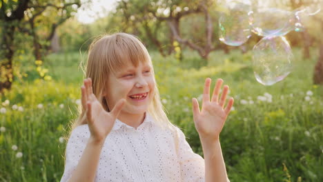 Carefree-Girl-Is-Catching-Soap-Bubbles-Cheerfully-A-Walk-In-The-Spring-Garden-Slow-Motion-Video