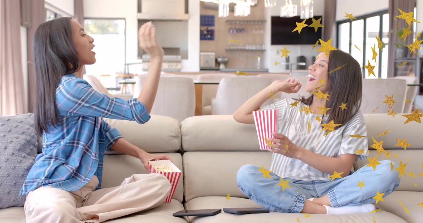 Kakak beradik mengambil popcorn dan melempar biji untuk hiburan yang mempererat ikatan dengan overlay konfeti bintang.