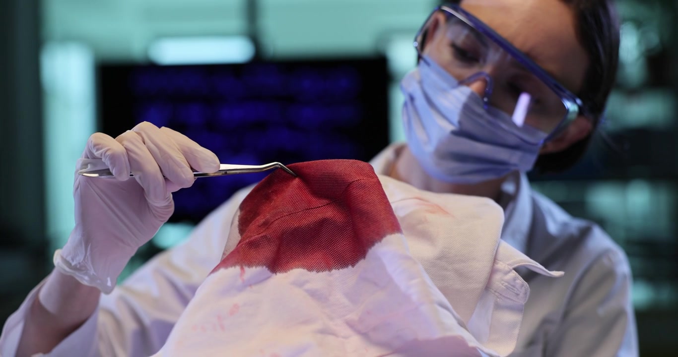 Female scientist research fabric with large red stain in lab