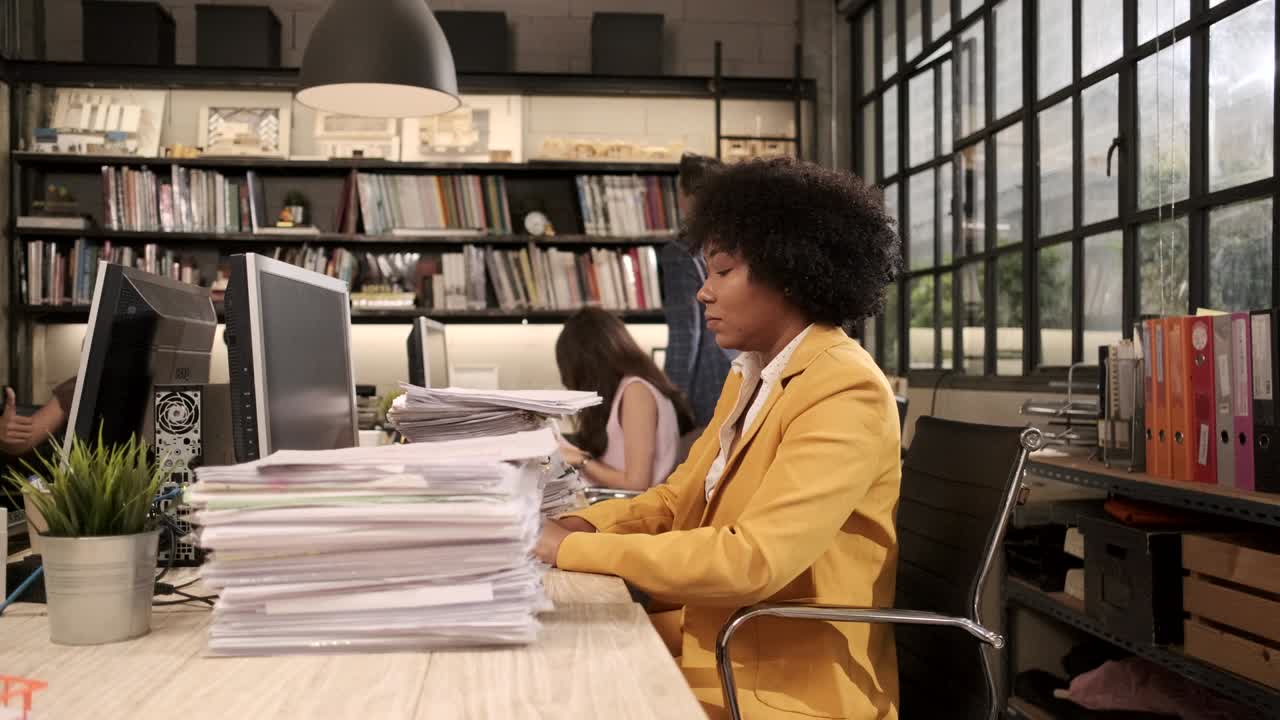 Busy young African American worker is hard working in a business office.