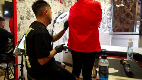artist prepares tools and cleans the client's arm, tattoo studio. pan right
