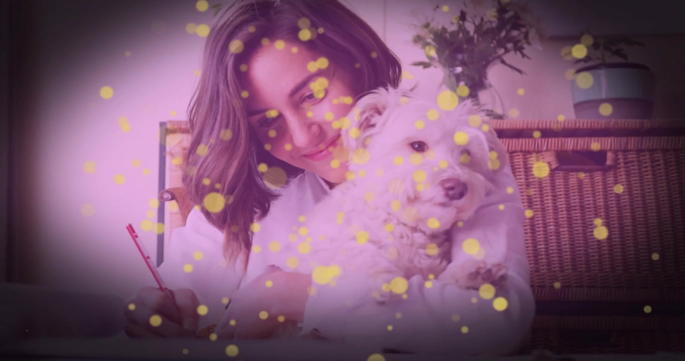 Perro subiendo al hombro de una mujer, lo que provoca que mueva el portátil, acunando a la mascota mientras escribe para diseño