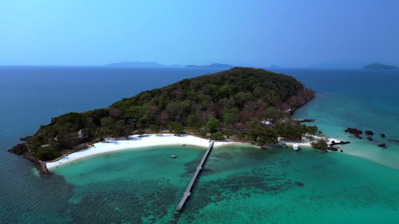 Koh Kham Island with crystal clear turquoise water, white sand beaches and lush tropical vegetation, a popular tourist destination in Thailand. Best aerial view flight drone shot footage from above