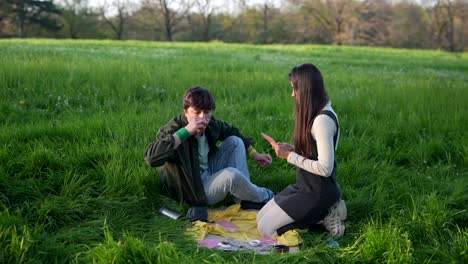 couple playing cards in a park
