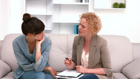 psychologist talking with her depressed patient and taking notes