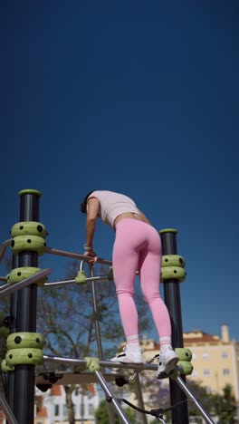 woman exercising on outdoor climbing equipment