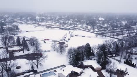 4k drone video of snow-covered baseball field at a school in winter in suburbs of grand rapids, michigan