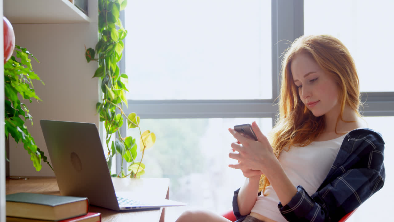 mujer ejecutiva usando portátil y teléfono móvil en la oficina 4k