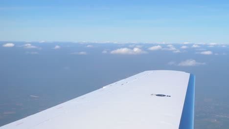 shot of the wing of a private jet flying through the sky