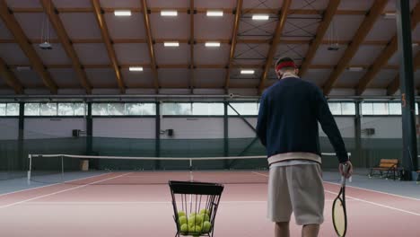 man playing tennis indoors