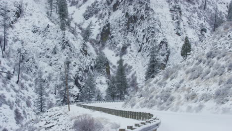 4x4-truck-drives-on-snow-covered-mountain-road-in-winter-with-steep-cliffs
