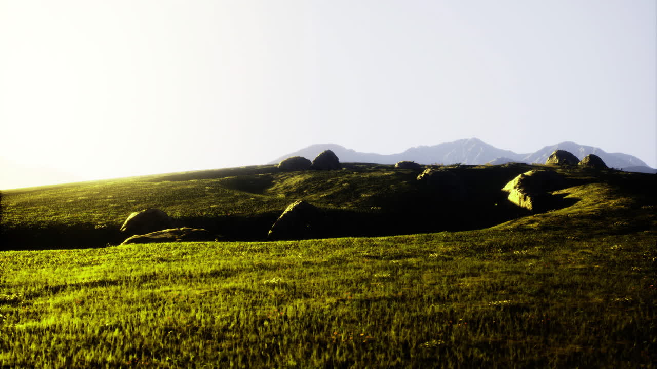 Scenic landscape with rolling hills and distant mountains during sunset